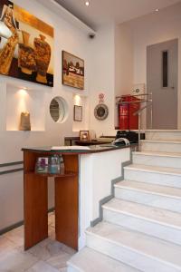 a room with stairs and a counter with a table at Metropolis Hotel in Athens