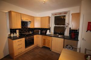 een keuken met houten kasten en een aanrechtblad bij 63 Argyle Street in Inverness +2 foto's