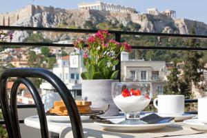 a table with a plate of food on a balcony at Metropolis Hotel in Athens