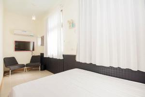 a bedroom with a bed and a window and a tv at Happiness B&B in Magong