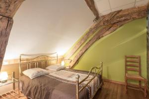 een slaapkamer met een bed en een houten vloer bij L'Hirondelle in Lantilly