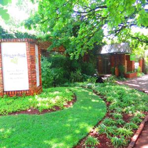 un jardín con una señal frente a un edificio en Huys ten Bosch, en Potchefstroom