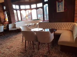 a restaurant with a couch and tables and chairs at The Wight Bay Hotel - Isle of Wight in Sandown