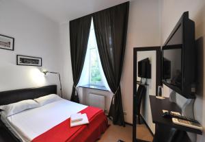 ein Schlafzimmer mit einem Bett mit einer roten Decke und einem Fenster in der Unterkunft Reno Hotel in Odessa