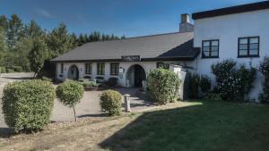 una casa blanca con una puerta y un patio en Dalby Hotel, en Haslev