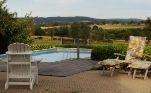 a group of chairs sitting next to a swimming pool at Appartement Hoeve Espewey - Leisure only in Hombourg
