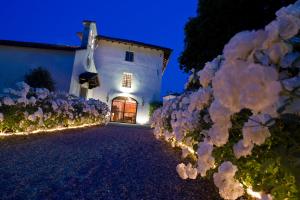 una casa bianca con un mazzo di fiori di notte di Borgo Dei Conti Della Torre a Morsano al Tagliamento