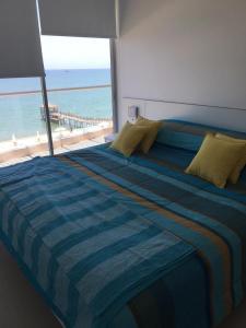 1 dormitorio con 1 cama grande y vistas al océano en Paracas departamento Condominio Nautico, en Paracas