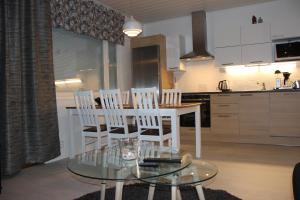 拉赫的住宿－Majoituspalvelu Nurmi Apartment Oksapolku 2 A Deluxe Huoneisto 60m3，厨房以及带玻璃桌和椅子的用餐室