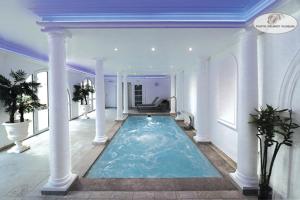 a large swimming pool in a mansion with a blue ceiling at Le Continental in Condom