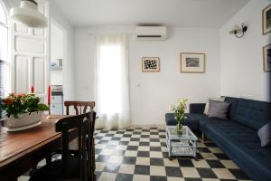 a living room with a blue couch and a table at Suites Machado in Seville