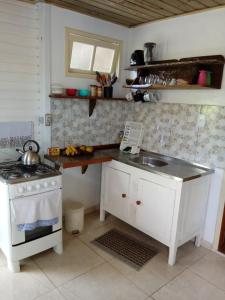a kitchen with a stove and a sink at Casa na Praia do Matadeiro in Florianópolis
