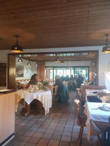 Ganerb في Dudenhofen: مطعم بالطاولات والناس جالسين على الطاولات