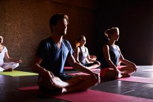 un grupo de personas sentadas en una clase de yoga en Companhia das Culturas - Ecodesign & Spa Hotel, en Castro Marim
