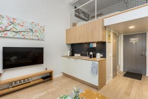 a living room with a tv and a kitchen at Angleterre Apartments in Tallinn