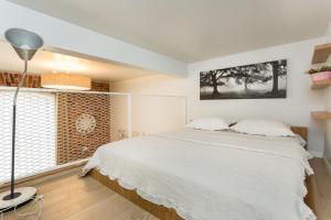 ein Schlafzimmer mit einem weißen Bett und einem Fenster in der Unterkunft Angleterre Apartments in Tallinn