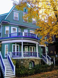 uma grande casa azul com um alpendre branco e corrimão azul em The Coolidge Corner Guest House: A Brookline Bed and Breakfast em Brookline