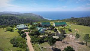 an aerial view of a house on a hill next to the ocean at TNiqua Stable Inn in Plettenberg Bay