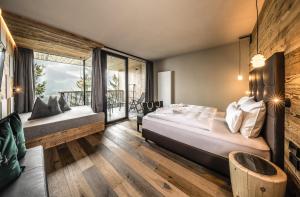 a bedroom with a large bed and a balcony at My Arbor - Plose Wellness Hotel in Bressanone