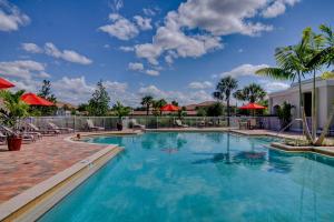 a swimming pool with blue water and red umbrellas at Fort Myers Luxury Vacation Condo in Fort Myers