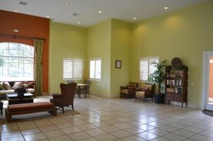 a living room with green walls and chairs and tables at Fort Myers Luxury Vacation Condo in Fort Myers +57 photos