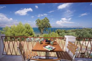 a table on a balcony with a view of the ocean at Villa Ostria in Lixouri