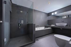 een badkamer met een douche, een toilet en een wastafel bij Villa Evian in PalaiónTsiflíkion
