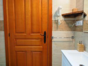 una puerta de madera en un baño con lavabo en Planet Ancares, en Candín