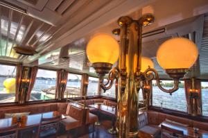 a dining room on a boat with windows at Kapitein Anna in Amsterdam