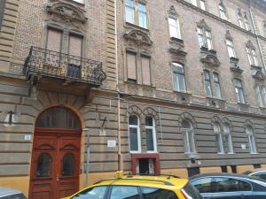 ブダペストにあるTravelers Apartmentの建物前に停車する黄色い車