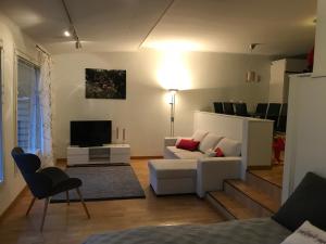 a living room with a white couch and a television at Arctic Sofia Riverstudio in Rovaniemi