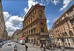um edifício alto com uma torre de relógio numa rua da cidade em Gulliver's Lodge em Roma