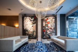 a lobby with two couches and chandeliers at Kyoto Shijo Takakura Hotel Grandereverie in Kyoto