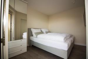sypialnia z dużym łóżkiem i lustrem w obiekcie Kurpark-Residenz W112 w mieście Cuxhaven