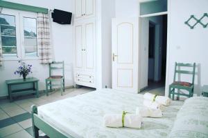アギア・マーリナにあるTassos Apartments IIの白いベッドルーム(ベッド1台、椅子2脚付)