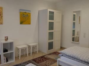 a bedroom with a bed and two stools in it at Moderne Wohnung in barockem Altstadthaus nahe Altstadt und Radweg in Blieskastel