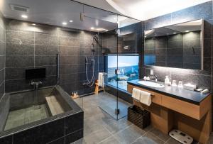 uma casa de banho com uma banheira, um lavatório e um chuveiro em Kyoto Shijo Takakura Hotel Grandereverie em Quioto