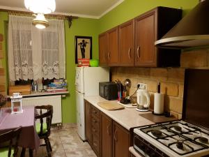 a kitchen with wooden cabinets and a stove top oven at Dom Gościnny Orange in Wysowa-Zdrój