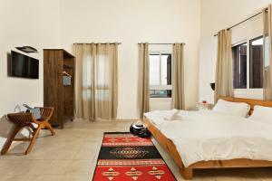 1 dormitorio con 2 camas, TV y alfombra en Fauzi Azar by Abraham, en Nazaret