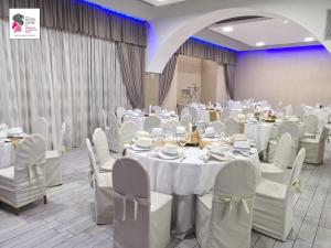 un salón de banquetes con mesas blancas y sillas blancas en Hotel Leon - Ristorante Al Cavallino Rosso, en San Giovanni Rotondo