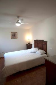 1 dormitorio con 1 cama blanca grande con lámpara en Ático del Holandés, en Balaguer