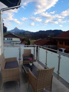 einen Balkon mit Stühlen, einem Tisch und Aussicht in der Unterkunft Haus am See in Füssen