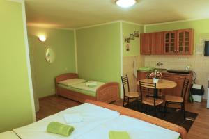 a bedroom with a bed and a table and a kitchen at Apartmány pri zámočku in Bešeňová +27 photos