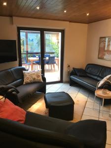 a living room with black couches and a television at Ferienhaus Lara in Heimbach