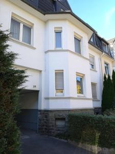 a white house with a garage in front of it at Lüdenscheid-Ferienwohnung de Betzler Weh29-100 in Lüdenscheid