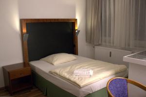a small bedroom with a bed with a black headboard at Porschepension in Wolfsburg +13 photos