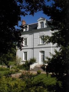 a white house with stairs in front of it at Le Chat Courant in Villandry