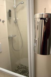 eine Spiegelreflexion einer Dusche im Badezimmerspiegel in der Unterkunft Porschepension in Wolfsburg