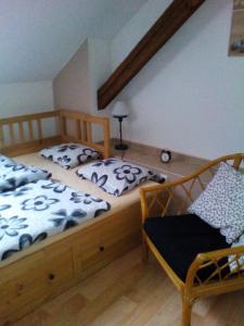 a bedroom with two beds and a chair at Apartmán Nerudovka in Kašperské Hory
