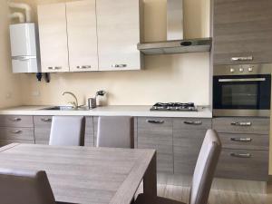cocina con mesa de madera y armarios blancos en Appartamento Quasi Perfetto en Sestri Levante